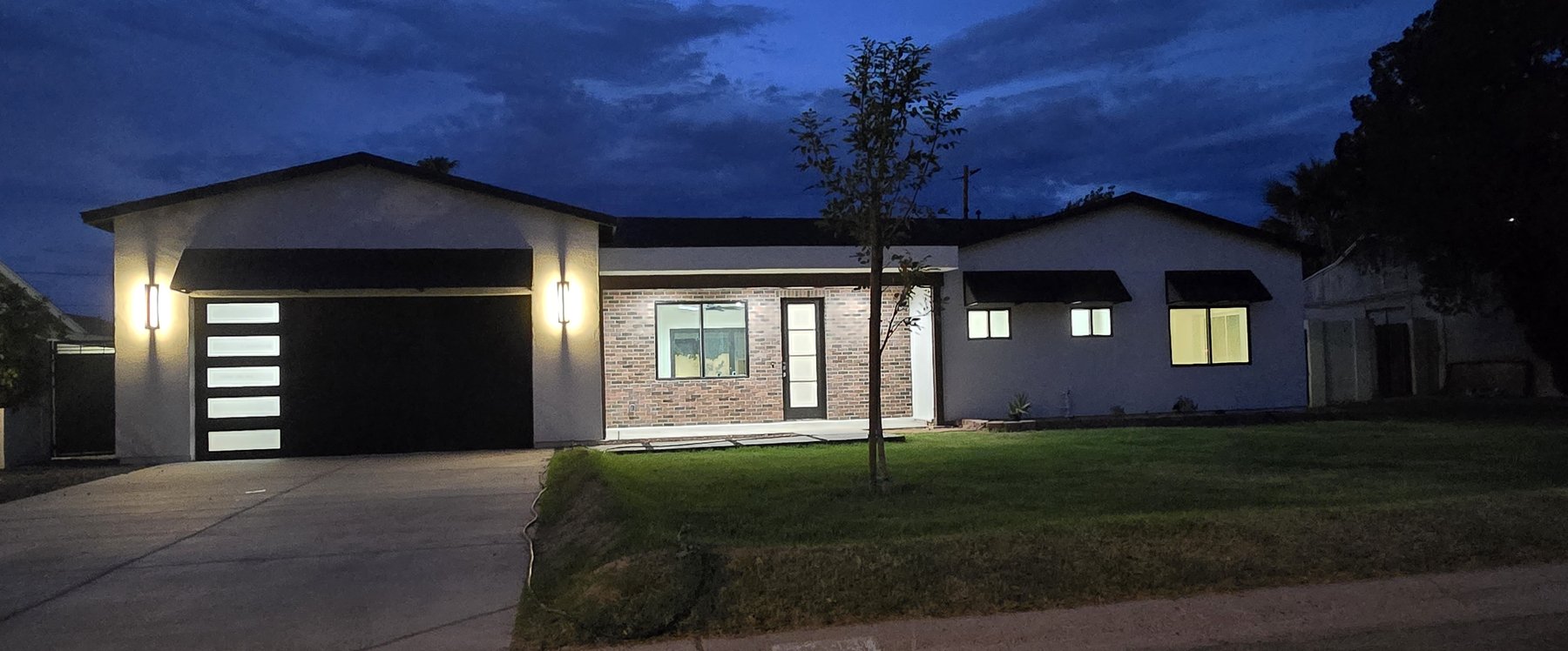 Real photo of front exterior at dusk, wider angle