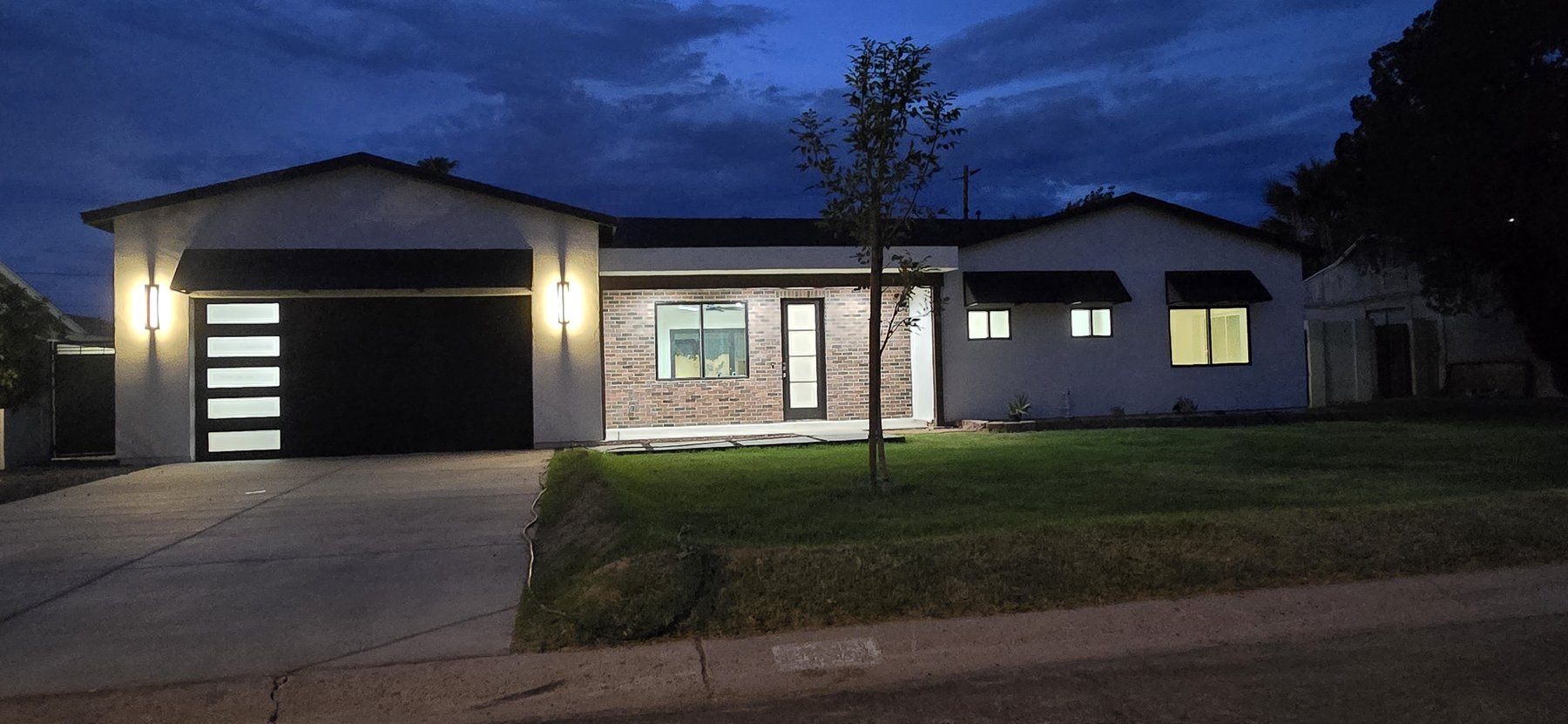 Real photo of front exterior at night with lit facade